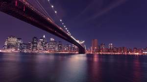 Gambar latar belakang PPT dari pemandangan malam jembatan di seberang lautan